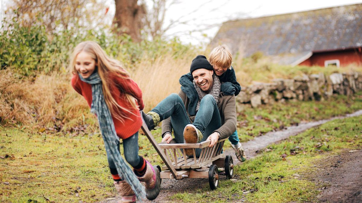 Father and children playing with a wagon